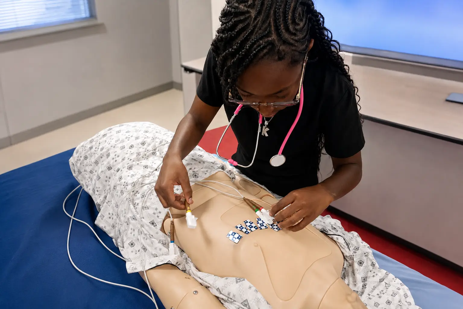 PETC Medical Assistant student practicing ECG lead placement on a training mannequin