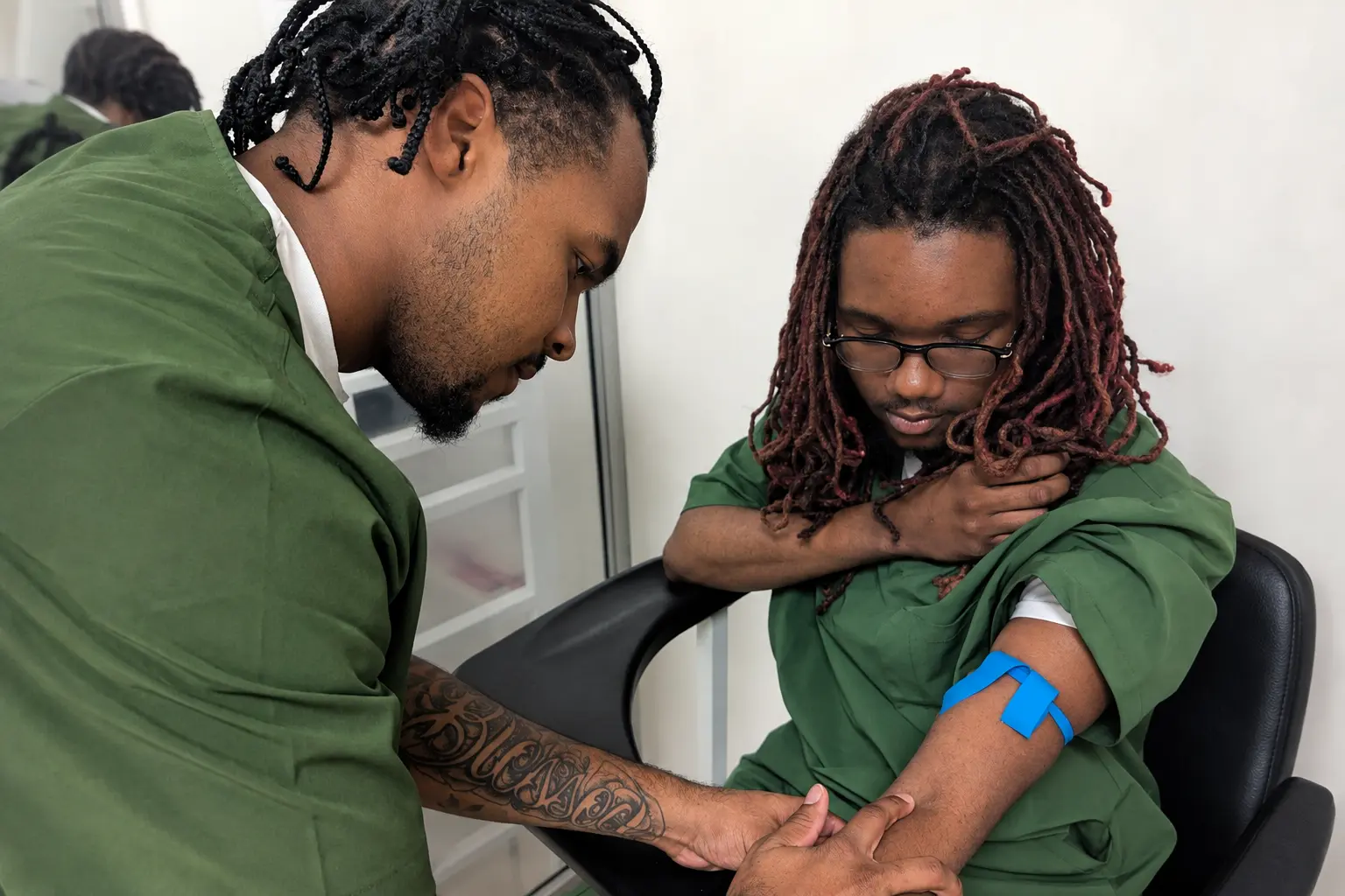PETC students practicing vein assessment and tourniquet placement during hands-on Phlebotomy Training